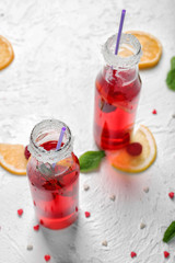 Bottles of fresh raspberry lemonade on white table
