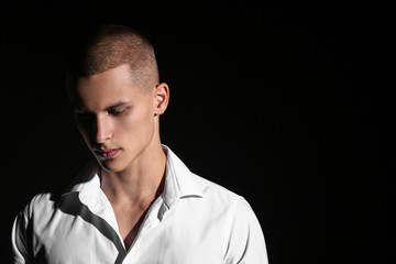 Sad teenage boy on dark background