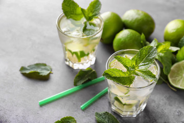 Glasses of fresh mojito on grey table