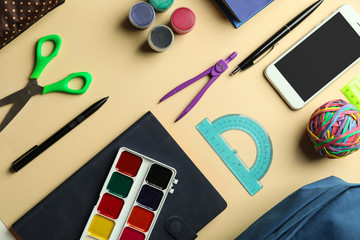 Composition with different school stationery and phone on light background