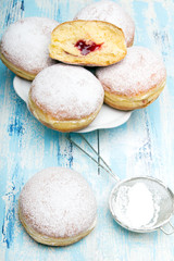 Traditional Polish donuts on wooden background. Tasty doughnuts with jam.