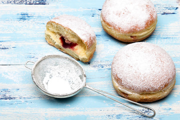 Tradycyjne Polskie pączki na drewnianym tle. Smaczne paczki z dżemem. © czarny_bez