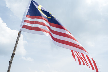 Obraz premium Malaysia flag also known as Jalur Gemilang wave with the blue sky. People fly the flag in conjunction with the Independence Day celebration or Merdeka Day.