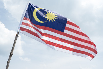 Malaysia flag also known as Jalur Gemilang wave with the blue sky. People fly the flag in conjunction with the Independence Day celebration or Merdeka Day.