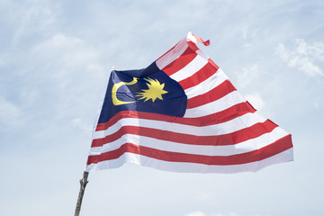 Malaysia flag also known as Jalur Gemilang wave with the blue sky. People fly the flag in conjunction with the Independence Day celebration or Merdeka Day.