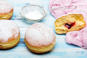 Tradycyjne Polskie pączki na drewnianym tle. Smaczne paczki z dżemem. © czarny_bez