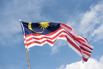 Malaysia flag also known as Jalur Gemilang wave with the blue sky. People fly the flag in conjunction with the Independence Day celebration or Merdeka Day.