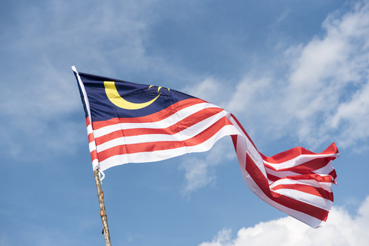 Malaysia flag also known as Jalur Gemilang wave with the blue sky. People fly the flag in conjunction with the Independence Day celebration or Merdeka Day.