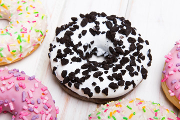 Traditional donuts on white wooden background.  Tasty doughnuts with icing, copy space