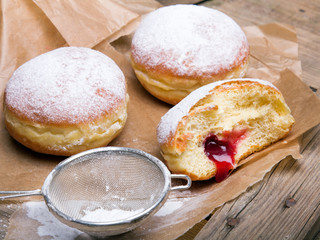 Traditional Polish donuts on wooden background. Tasty doughnuts with jam.
