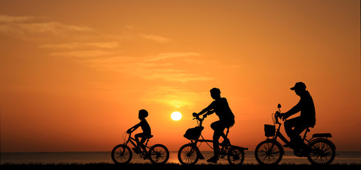 silhouette family  riding bicycle at sunset sky