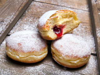 Traditional Polish donuts on wooden background. Tasty doughnuts with jam.