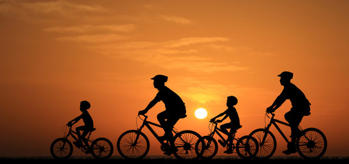silhouette family  riding bicycle at sunset sky