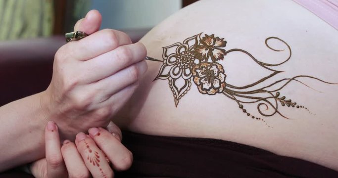 Drawing a mehendi on the stomach