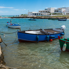Fototapeta na wymiar Enchanted sea. Boats in the bay of the abbey of San Vito