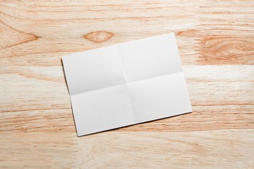 Blank portrait mock-up paper. brochure magazine isolated on brown wooden table, changeable background / white paper isolated on wood