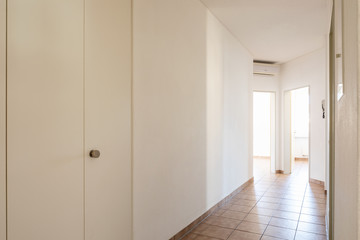 White corridor with tiles and open doors