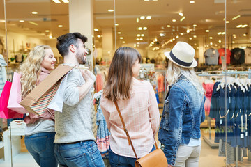 Junge Leute beim Shopping vor Modeladen