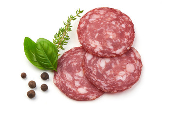 Sliced salami smoked sausage, basil leaves and peppercorns, isolated on white background.