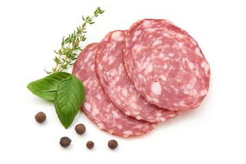Sliced salami smoked sausage, basil leaves and peppercorns, isolated on white background.