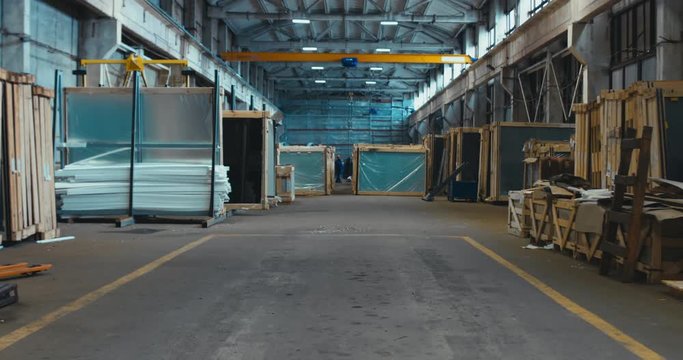 FIXED unrecognizable people working in a large warehouse, worker moving crane beam with a remote controller. 4K UHD