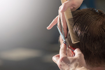 Hairdresser cutting hair of customer at salon.