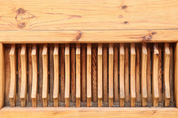 Fragment of a wooden wall with a carved vertical grid