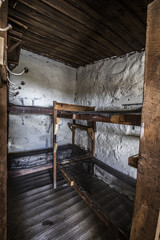 Bunk beds inside an old Andean mountain shelter at San Jose Volcano in Central Andes, Chile