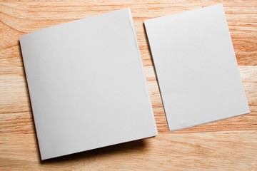Blank portrait mock-up paper. brochure magazine isolated on brown wooden table, changeable background / white paper isolated on wood