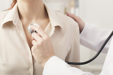 Doc with stethoscope checking patient heart beat