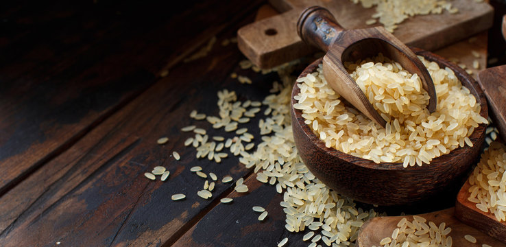 Parboiled rice in a wooden bown with a spoon