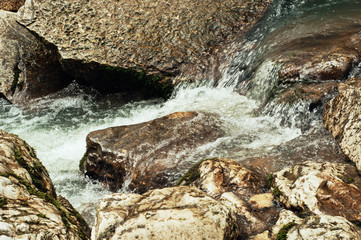 Cascade of a mountain river. Background in warm tones. - 220117980