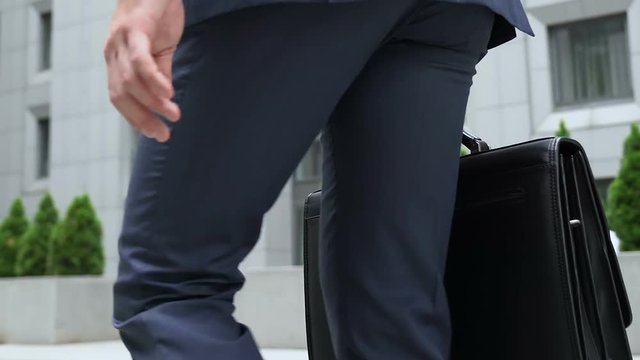 Busy man hurrying to work, attorney going to court building, legs closeup