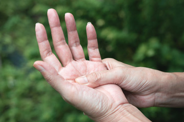 Closeup hand of person massage her hand from pain in healthy concept on nature background.