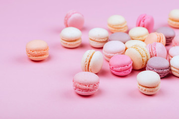 Group of sweet pink and white mini macarons on soft pink paper