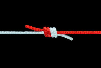 Tie the knot with red and white rope on black background, with clipping path