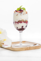 yogurt with muesli and berries in glass isolated on white background