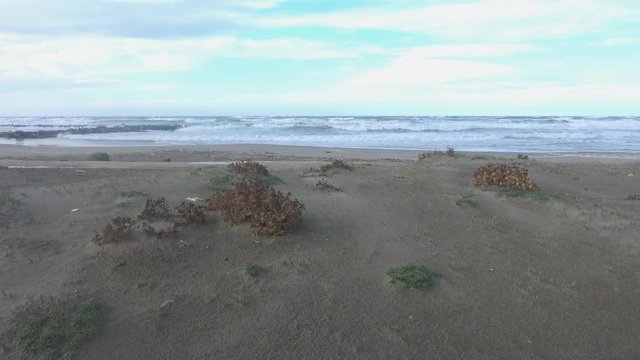 Waves rolling on the beach is a stormy day, winter mediterranean sea. Focene, Lazio, Italy. 4k