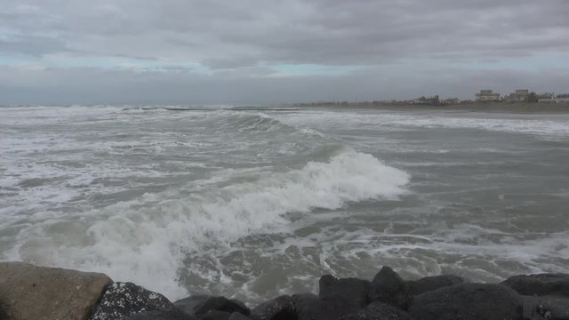 Waves rolling on the beach is a stormy day, winter mediterranean sea. Focene, Lazio, Italy. 4k