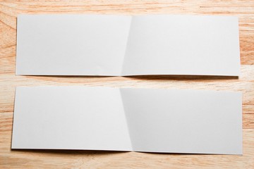 Blank portrait mock-up paper. brochure magazine isolated on brown wooden table, changeable background / white paper isolated on wood