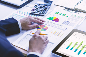 Businessman is deeply reviewing a financial report for a return on investment or investment risk analysis.