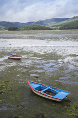 Boats stranded at the mouth of a river at low tide