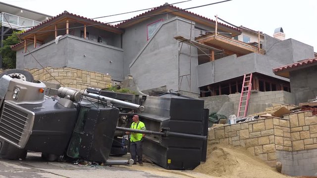 A dump truck rolls over during an accident on a construction site.