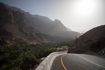 Straße durch Berge und Pflanzen im Oman