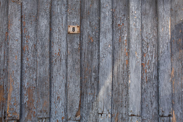 Obraz premium old wooden door with peeling and cracked grey paint