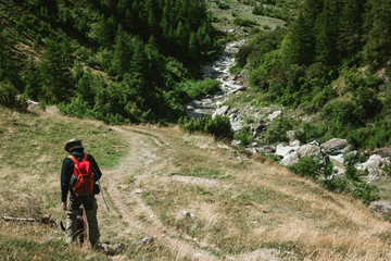 Fototapeta na wymiar Hiking man with dog in the Mountains of Switzerland