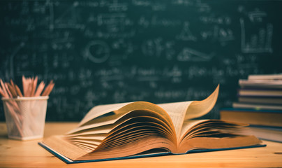 Open books with formulas on the chalkboard