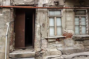 Fototapeta na wymiar old collapsing house with a wooden door and windows