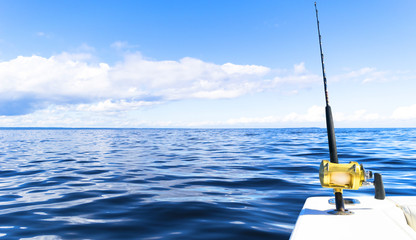 Fishing rod in a saltwater private motor boat during fishery day in blue ocean. Successful fishing...