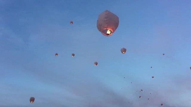 Group of sky lanterns floating away at dusk